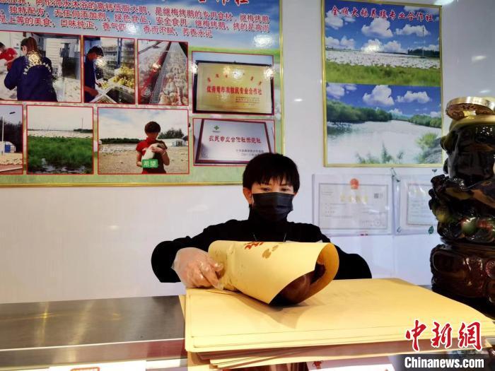 圖為鄭繼梅正在打包烤鵝。　謝宏秀供圖